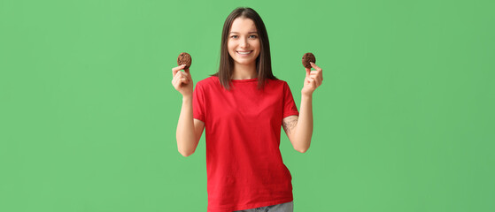 Canvas Print - Beautiful young woman with tasty cookies on green background