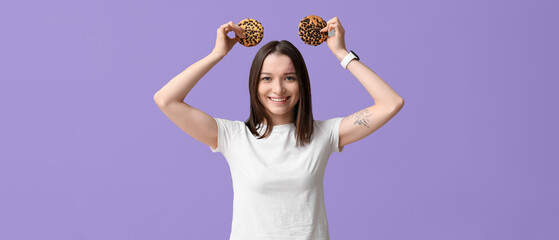 Canvas Print - Funny young woman with tasty cookies on lilac background