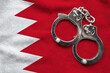 Flag of Bahrain and police handcuffs. Crime and offenses in country Concept
