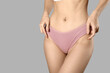 © Pixel-Shot - Young woman in panties on grey background