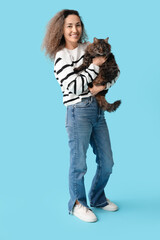 Wall Mural - Happy mature woman with cute cat on blue background