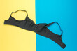 Black women's bra on a yellow and blue background.