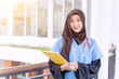Closeup Asian Female doctor in hijab portrait of cheerful happy holding a clipboard in medical blue shirt and glasses with stethoscope on modern clinic office and sun fare background.