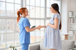 © Pixel-Shot - Young pregnant woman with doctor shaking hands in clinic