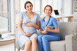 © Pixel-Shot - Young pregnant woman with doctor sitting on sofa in clinic