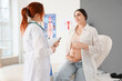 © Pixel-Shot - Young pregnant woman visiting doctor in clinic