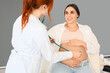 © Pixel-Shot - Female doctor with stethoscope examining pregnant woman on couch in clinic