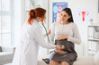 © Pixel-Shot - Female doctor with stethoscope examining pregnant woman in clinic