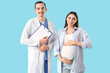 © Pixel-Shot - Young pregnant woman and doctor with clipboard on blue background