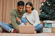 © peopleimages.com - Couple, people and Christmas with credit card on laptop with online shopping for festive season, gift and presents. Relationship, love and home with people for internet banking, spending and holiday