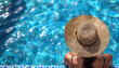 Woman wearing sun hat relaxing in swimming pool