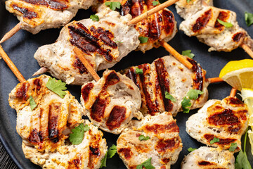 Wall Mural - grilled mini pork skewers on a plate, top view