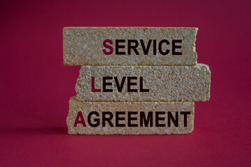 SLA service level agreement symbol. Concept words SLA service level agreement on brick blocks. Beautiful red background. Business SLA service level agreement concept.