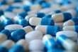 Close-up blue and white capsules and pills. Concept of opioid addiction or health care.