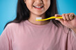 Close up of girl hands hold toothbrush isolate on blue background.