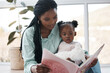 © peopleimages.com - House, baby and mother reading a book, relax and bonding together with happiness, language and storytelling. Childhood, black family and parent with love, mama and kid with fairytale and learning