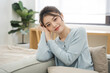 © Q88 - Portrait of Asian woman sitting on sofa at home