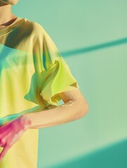 Poster - Young Caucasian Woman Adjusting Colorful Tee on Mannequin in Studio with Soft Green Background, Demonstrating Textile Simulation in Minimalist Advertising Setup