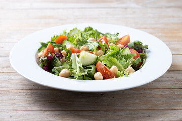 Wall Mural - Healthy chickpea salad with tomato,lettuce and cucumber on wooden table