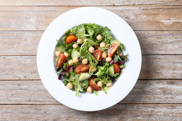 Poster - Healthy chickpea salad with tomato,lettuce and cucumber on wooden table. Top view