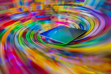 Wall Mural - Close-up of a credit card resting on a keyboard, the webpage blurred into a swirl of colorful product images