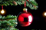 Fototapeta Do przedpokoju - A red Christmas ornament hangs from a tree