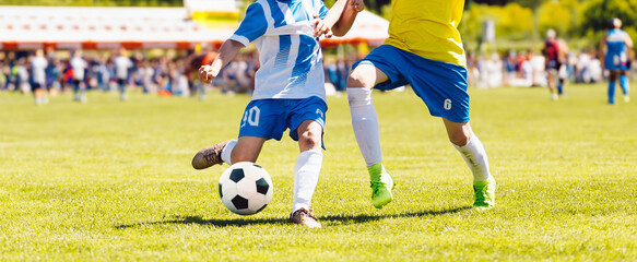 Wall Mural - Young boys playing soccer game. Kids having fun in sport. Happy kids compete in football game. Running soccer players. Competition between players running and kicking football ball. Football school