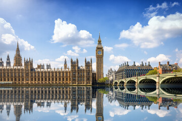 Wall Mural - Summer view of the Westminster Bridge and Palace with Big Ben clocktower in London, England, with sun, clouds and reflections in the river Thames