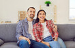 Young happy couple smiling sitting together close, man woman pair. Male, female partner on couch wearing casual wear, checked shirts, small family new flat, healthy communication and understanding