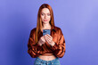 Photo of pretty young woman use smart phone empty space wear brown shirt isolated on violet color background