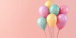 A bunch of vibrant pastel-colored balloons float with a sense of jubilance, suggesting celebration, joy, and party vibes on a soft pink background