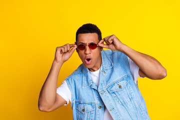 Canvas Print - Photo of handsome impressed man dressed denim vest over t-shirt touch sunglass astonished staring isolated on yellow color background