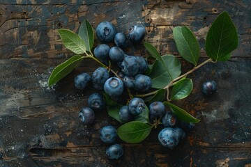 Wall Mural - Overhead view of a bunch of blueberries with green leaves, resting on a rustic wooden table