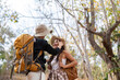 © Natee Meepian - Happy LGBT lesbian couple travel enjoy hiking with backpack in forest trail