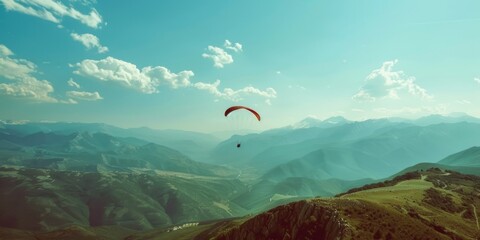 Wall Mural - A man is flying a parachute in the sky above a mountain range