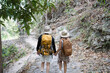 © itchaznong - Happy LGBT Lesbian couple Travelers Hiking with Backpacks in waterfall Trail. LGBT Lesbian Couple Hikers with backpacks walks in mountains in vacation