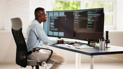 African American Coder Using Computer At Desk