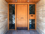 Fototapeta Big Ben - A contemporary design house entrance with a wood and glass door between stonewalls.Travel to Athens, Greece.