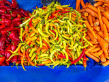 Fototapeta Big Ben - Green and red hot chilli peppers for sale at the local market. Colorful, natural pattern top view closeup.