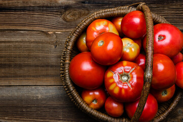 Wall Mural - Basket of fresh tomatoes on wooden table, top view.