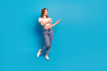 Poster - Full size photo of nice young girl point fingers empty space wear top isolated on blue color background