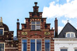 Historic house facades in brick construction with decorations and the year of construction in the city of Delft in the Netherlands