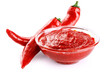 Gochujang Korean traditional spicy fermented sauce in a bowl and chili pepper isolated on white background. With clipping path.