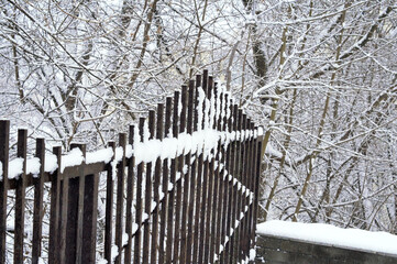 An old forged fence in the snow after a snowfall