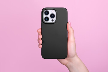 iphone 15 pro in female hand in black silicone cover isolated on pink background, phone case mock up