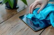 Hand cleaning tablet screen with microfiber cloth