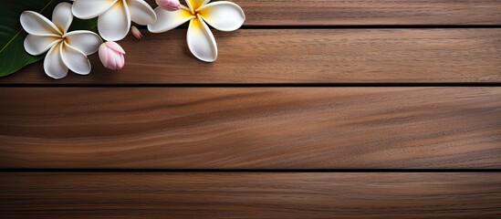 Poster - Top down view of a spa environment featuring a plumeria flower gracefully placed on a wooden table creating an inviting copy space image