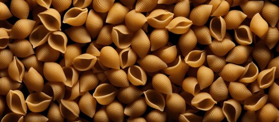Poster - A top down view of a dry shell pasta pattern on a black background creating a flat lay texture for a copy space image