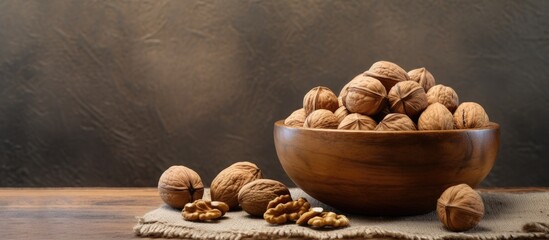 Wall Mural - A copy space image of walnuts arranged in a wooden bowl on a textured surface seen from the side creating a visually appealing composition of healthy nuts and seeds