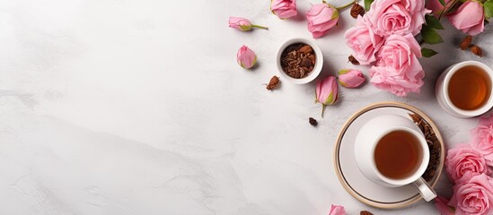 Poster - A top down view of rose tea along with cups and a teapot is showcased on a light gray background The image offers a wide perspective and includes open space. Creative banner. Copyspace image
